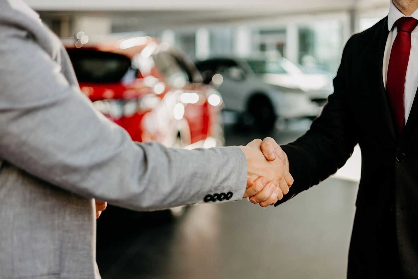 Executive handshake at a luxury car showroom